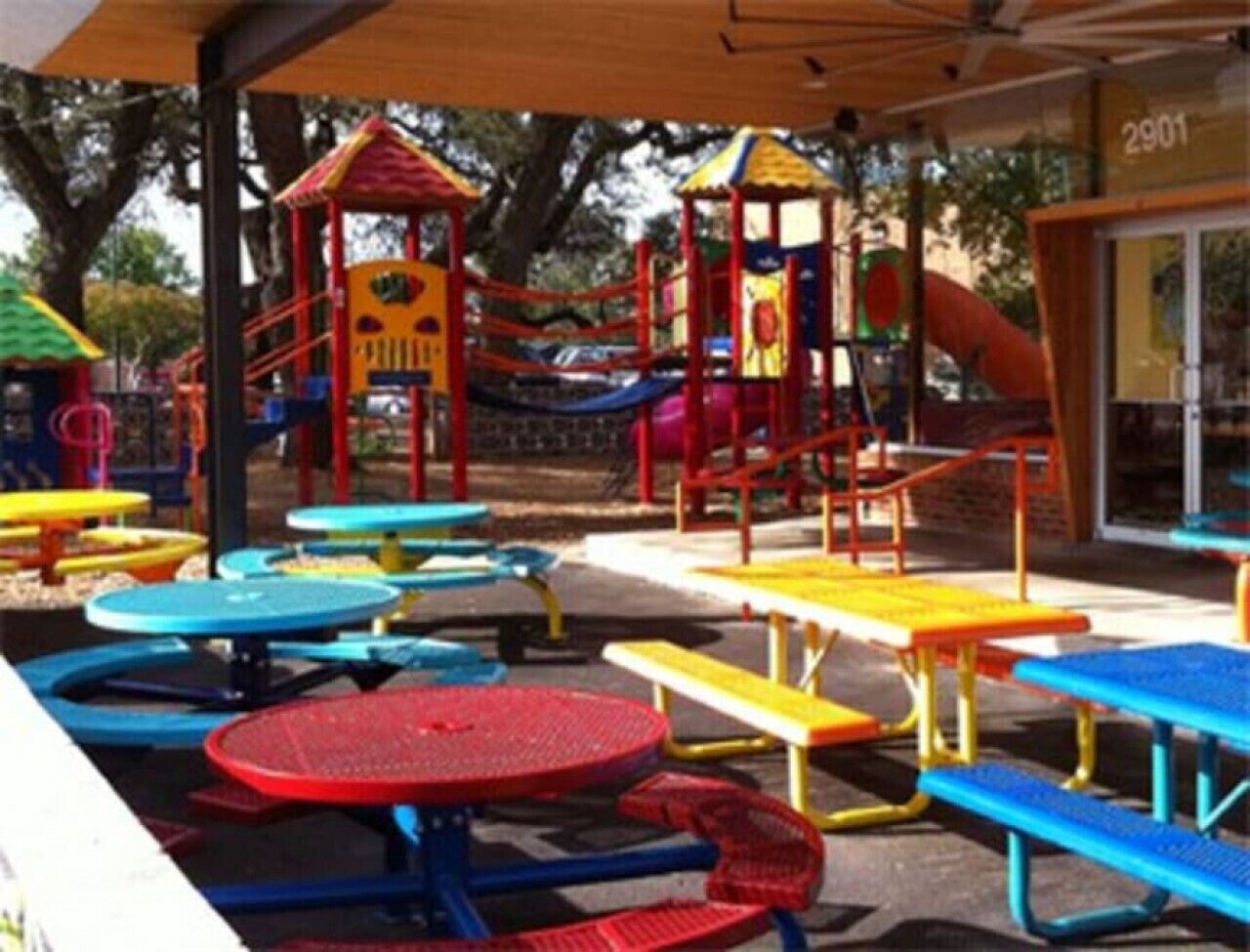 A playground with colorful play structures and picnic tables.