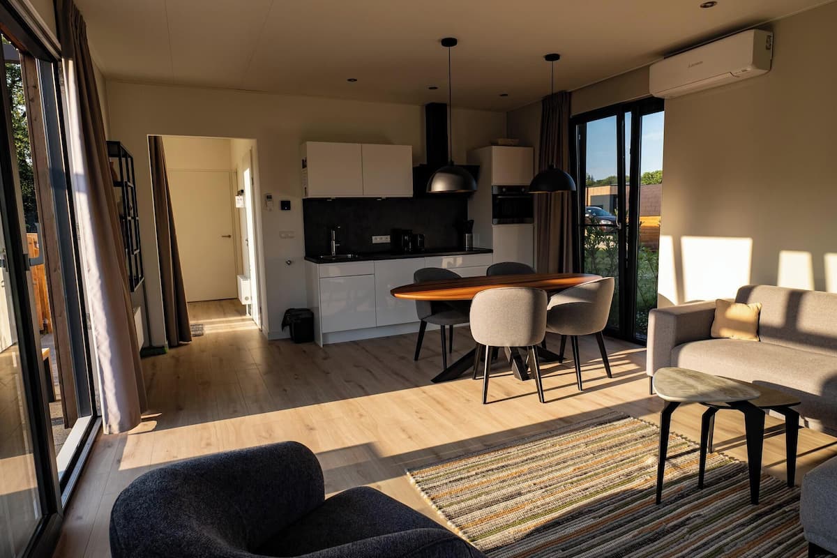 A modern apartment with a kitchen, dining area, and living room.