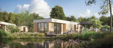 A modern building with large windows, a pond, and surrounding greenery.