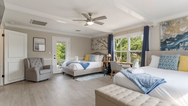 Une chambre à coucher avec un lit, une chaise, un bureau et un ventilateur de plafond.