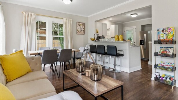 Un salon moderne comprenant un canapé, un coin repas, une cuisine et un bar.