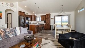 A spacious living room with a sofa, a coffee table, and a dining area with a table and chairs.