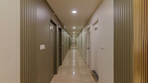A long, narrow hallway with doors on both sides, leading to individual rooms. - Treebo Raghavendra Tranquil Inn Bellandur (Bengaluru)