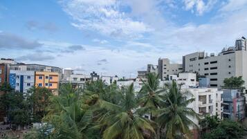 A residential area with multi-story buildings, some with balconies, and palm trees in the foreground.