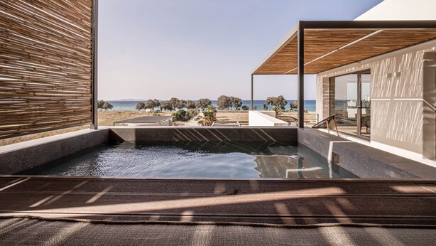 Un espace spa moderne doté d’une piscine, d’un plafond en bois et offrant une vue sur la plage.