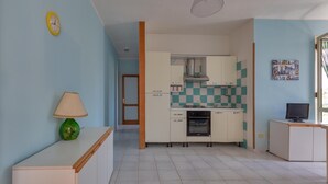 Una cocina compacta con microondas, horno y salpicadero a cuadros.