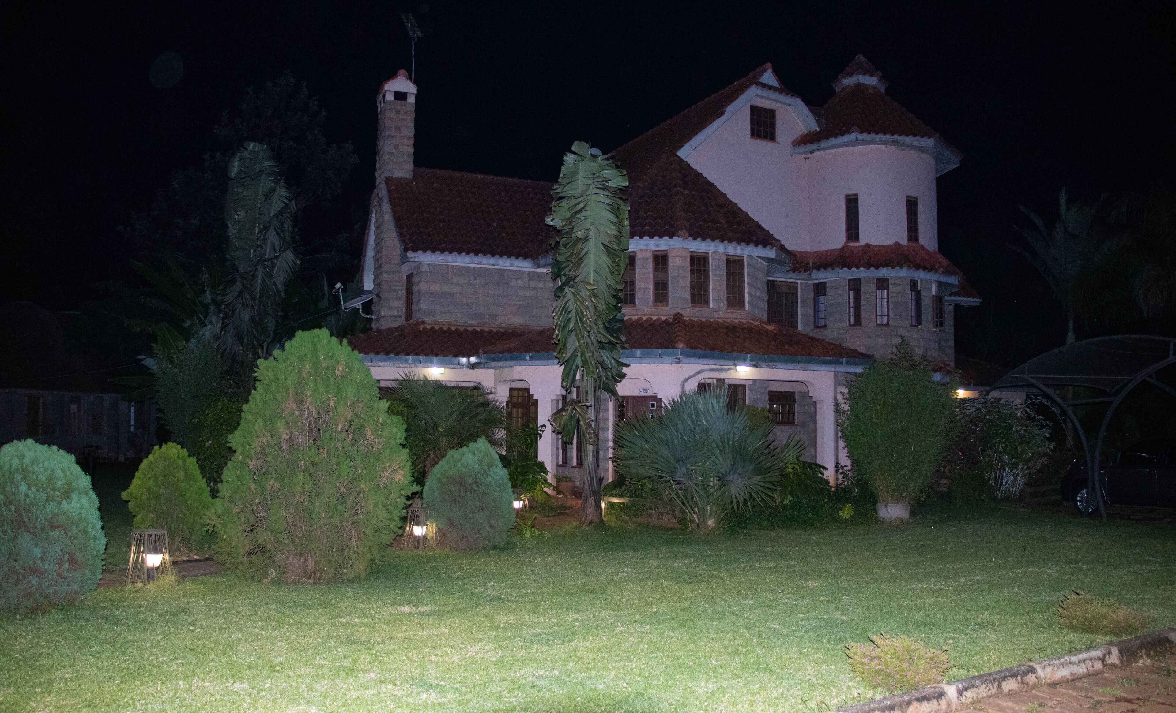 A large, two-story house with a stone facade and a red-tiled roof.