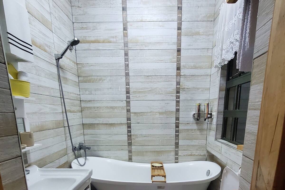Un baño pequeño con una bañera independiente, inodoro y lavabo.
