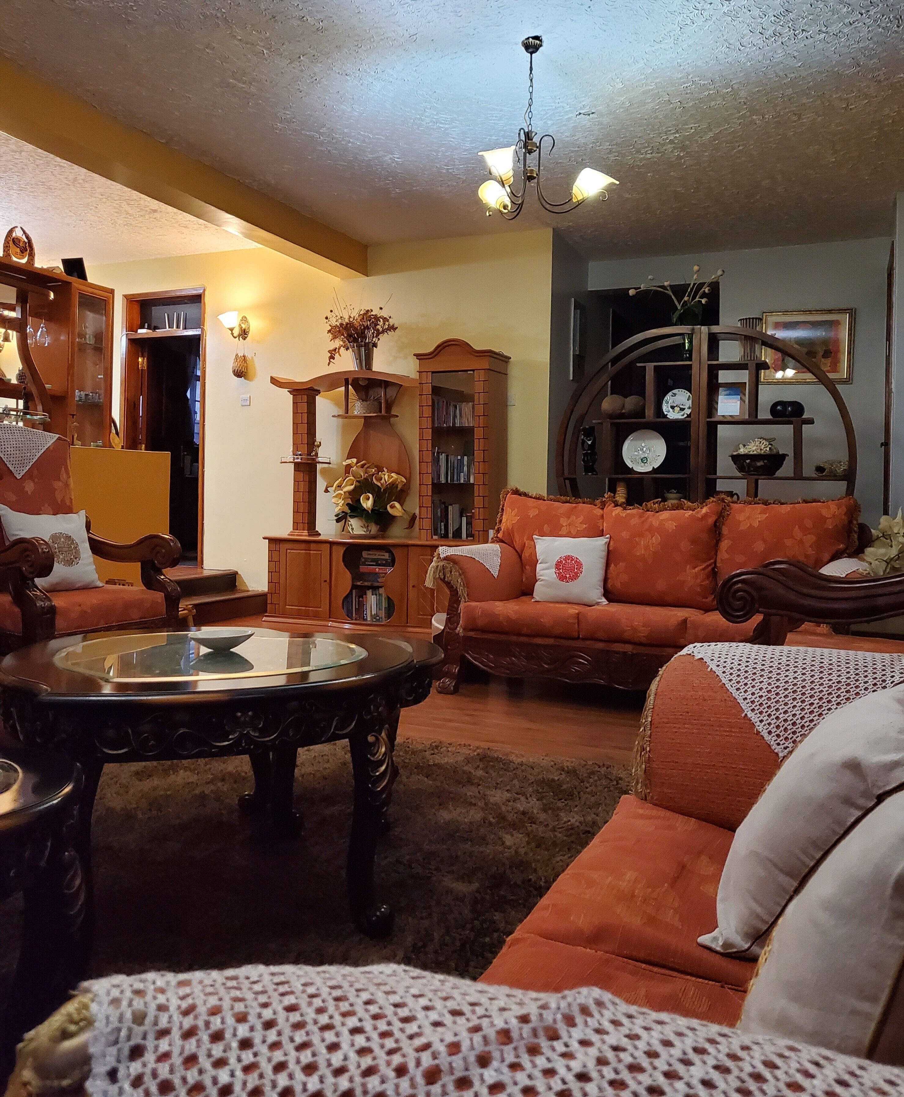 A cozy living room with a wooden coffee table, a sofa, and a bookshelf.