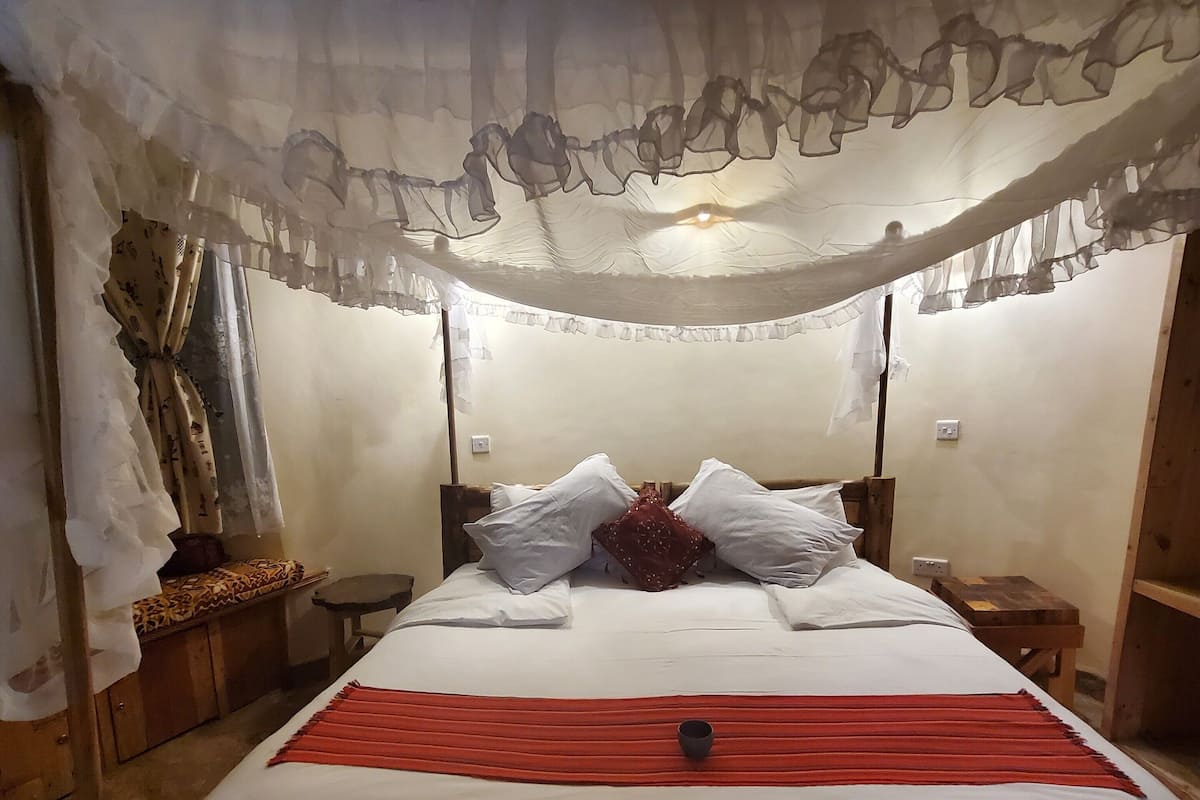 Una habitación con una cama, una mesita de noche y un cabecero de madera.