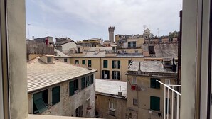A view of a densely packed urban area with historic buildings, including a tower and a bell tower, through a window.