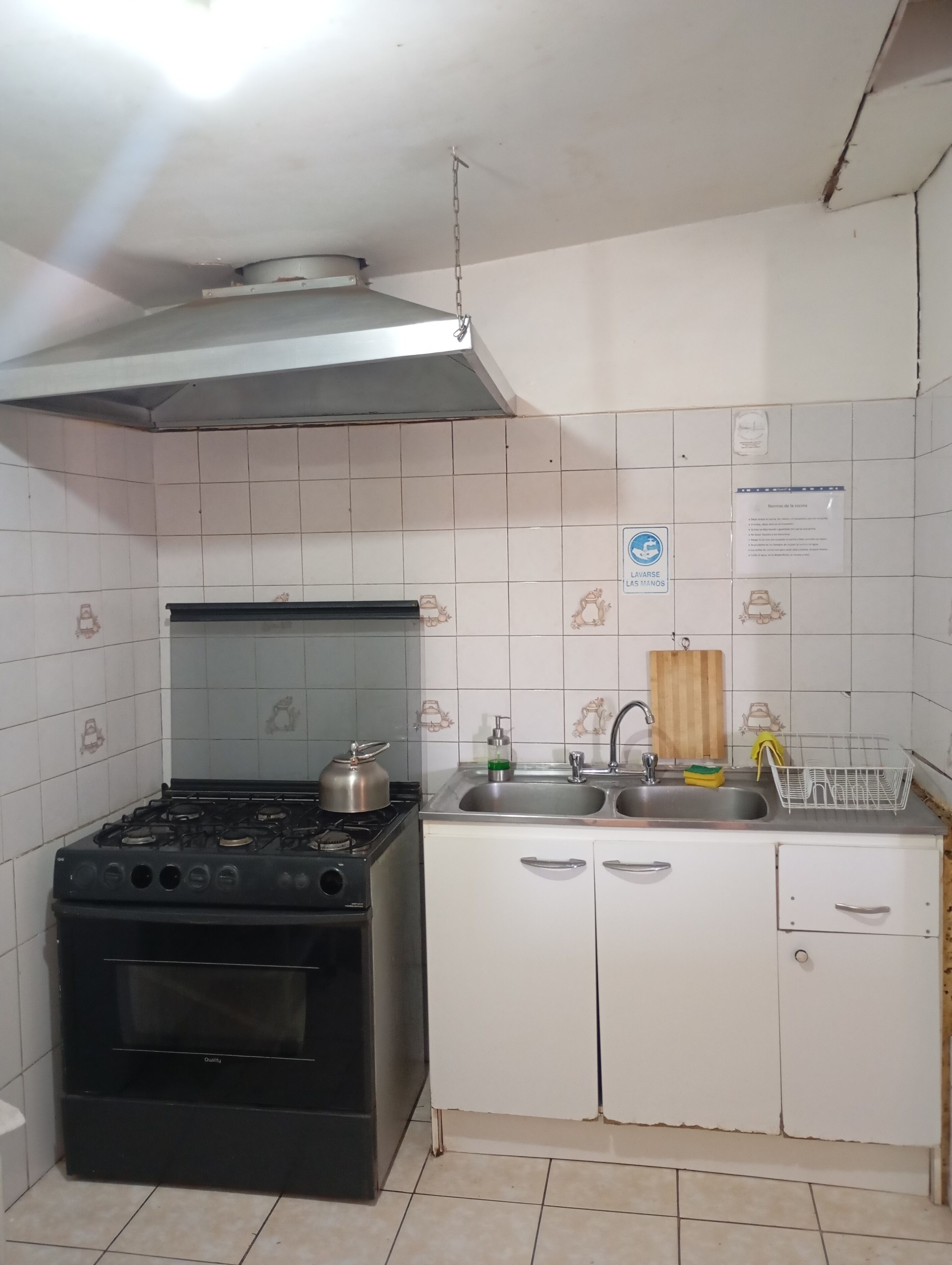 A kitchen with a stove, sink, and cabinets.