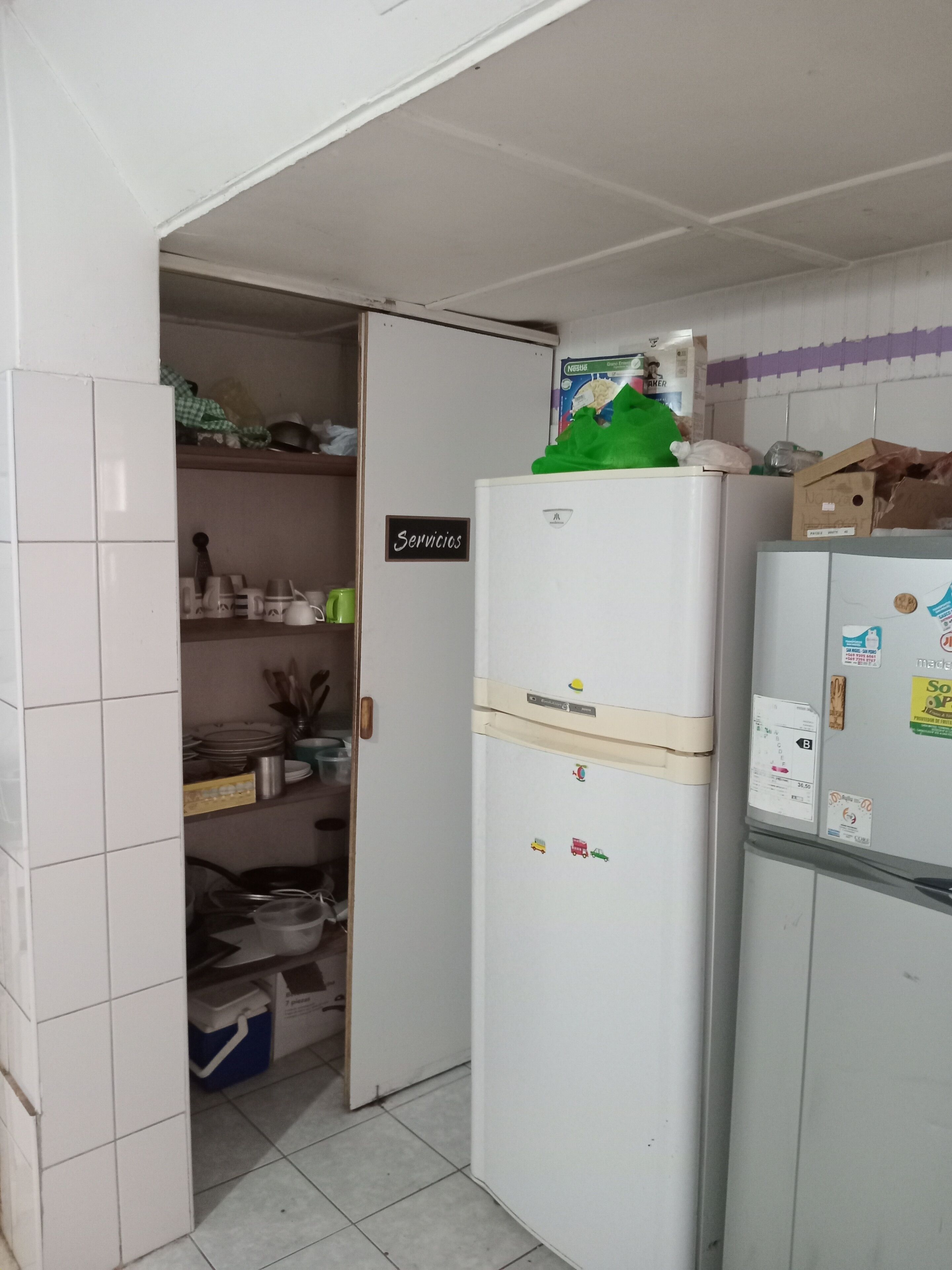 A compact kitchen with a white refrigerator, a freezer, and a small pantry area.