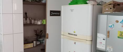 A compact kitchen with a white refrigerator, a freezer, and a small pantry area.