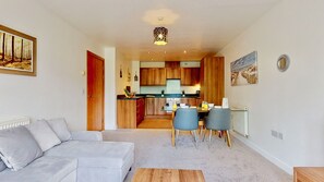 Cozy living space with a sofa, dining table, and kitchen area.