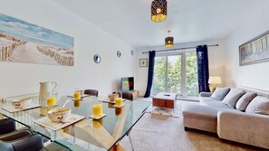 Relax in this stylish living room with a sofa, dining table, and large window.
