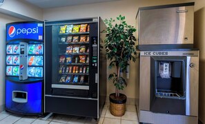 Un distributeur automatique orné du logo Pepsi, proposant une variété de collations et muni d’un distributeur de glaçons.