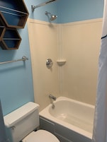 Bañera con ducha, secador de pelo, toallas, papel higiénico