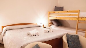 A bedroom with a bunk bed, a single bed, and a chair. - [Apartment in the Charming Courtyard] Lake Lugano (Brusimpiano)