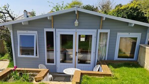 A small, single-story house with a patio area featuring a table and chairs.