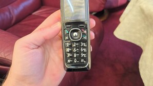 A person holding a Panasonic mobile phone.