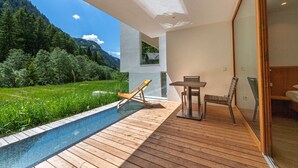 A modern outdoor deck with a pool, wooden furniture, and a view of a forested mountain. - 192A Greva Apartments 2 (Santa Cristina Valgardena)
