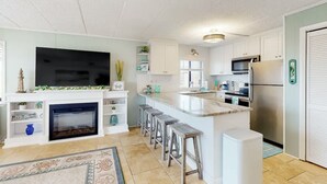 Eine moderne Küche mit einer großen Kochinsel, integrierten Geräten und einem Kamin.