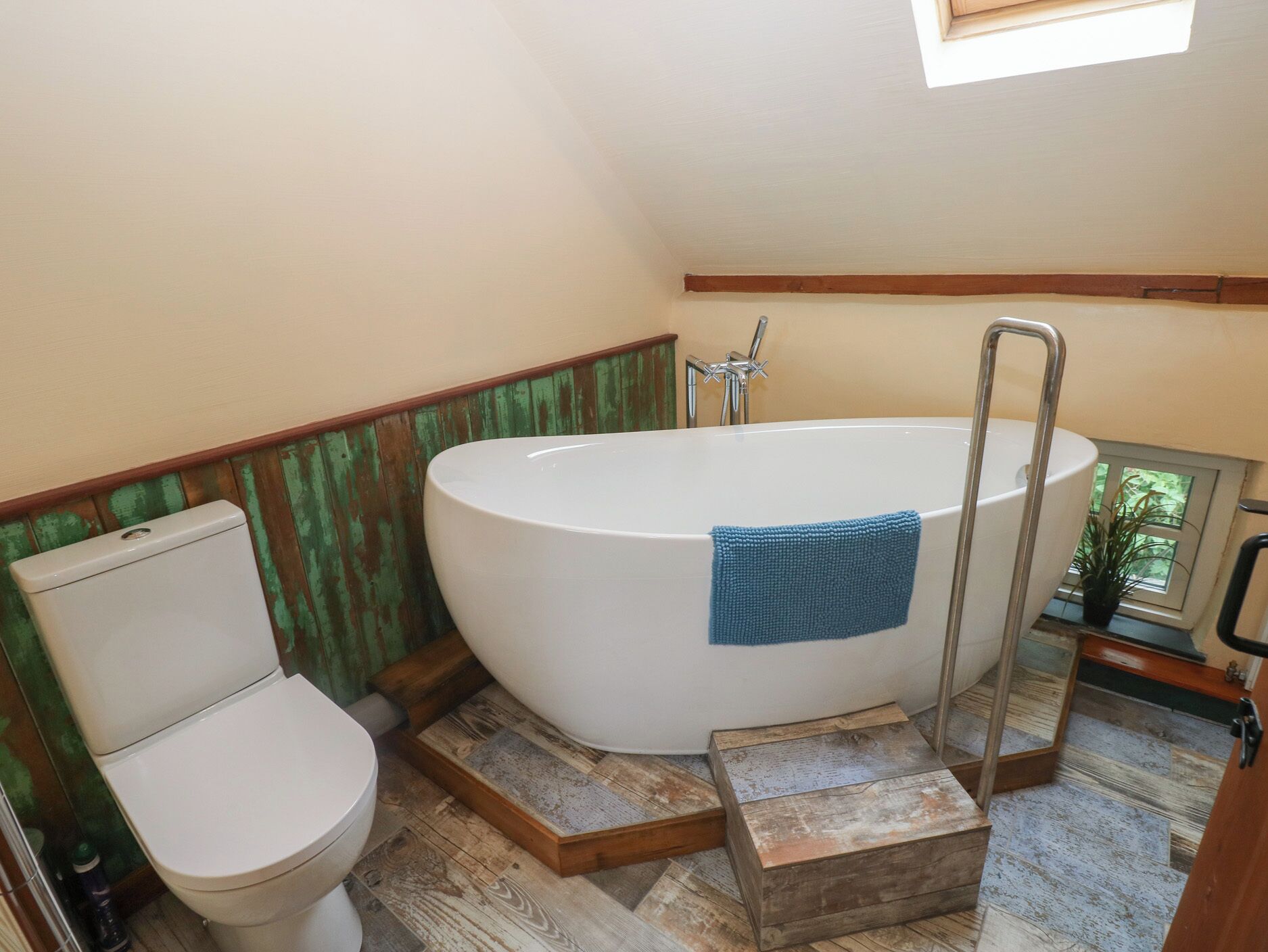 Une salle de bain comprenant des toilettes, une baignoire et un espace douche.