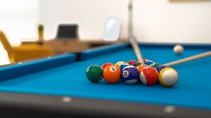 Une table de billard avec des billes de couleurs vives et un queue de billard.