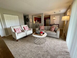 Relax in this stylish living room with a sofa, armchair, and coffee table, perfect for unwinding after a day out.