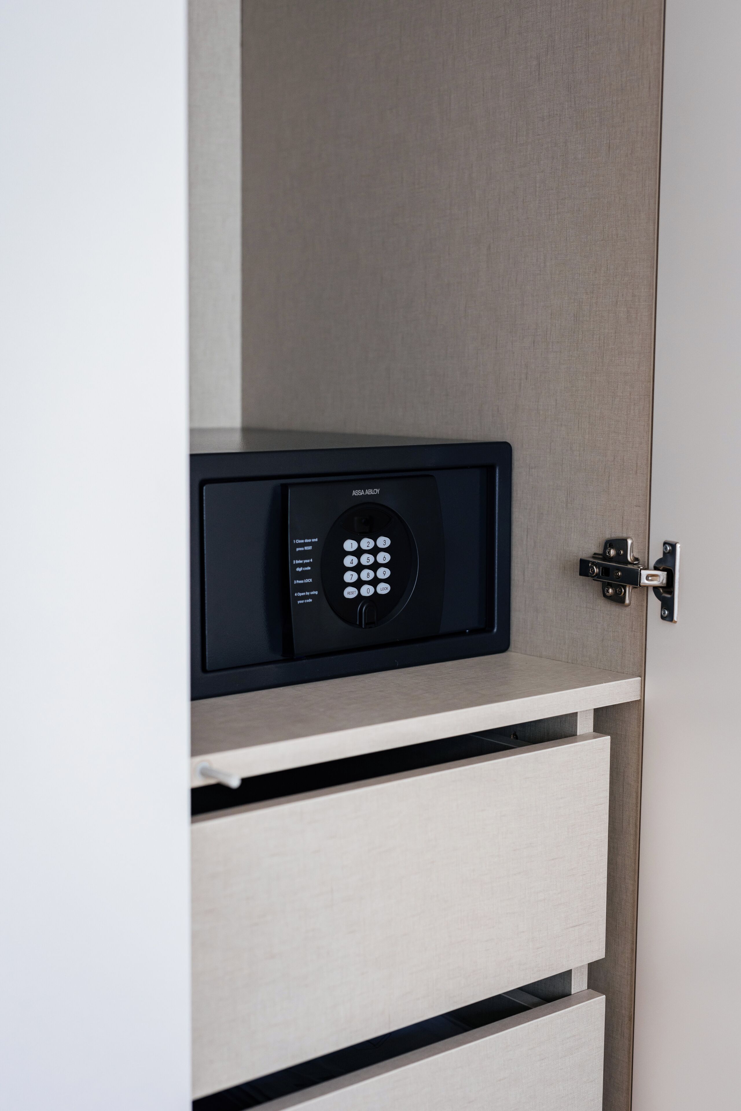Un appareil électronique noir doté d’un clavier situé sur la porte d’un meuble.