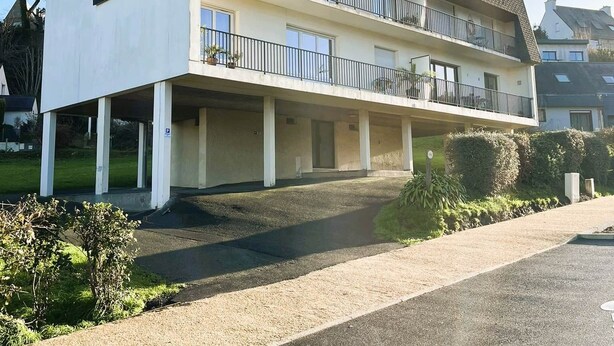 A two-story building with a flat roof, a balcony on the upper floor, and a covered parking area. - Traezh Ar Vag - Apartment Beach Perros-Guirec (Perros-Guirec)