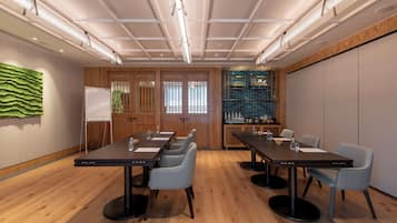 Un salón de conferencias con una larga mesa, varias sillas y una pizarra.