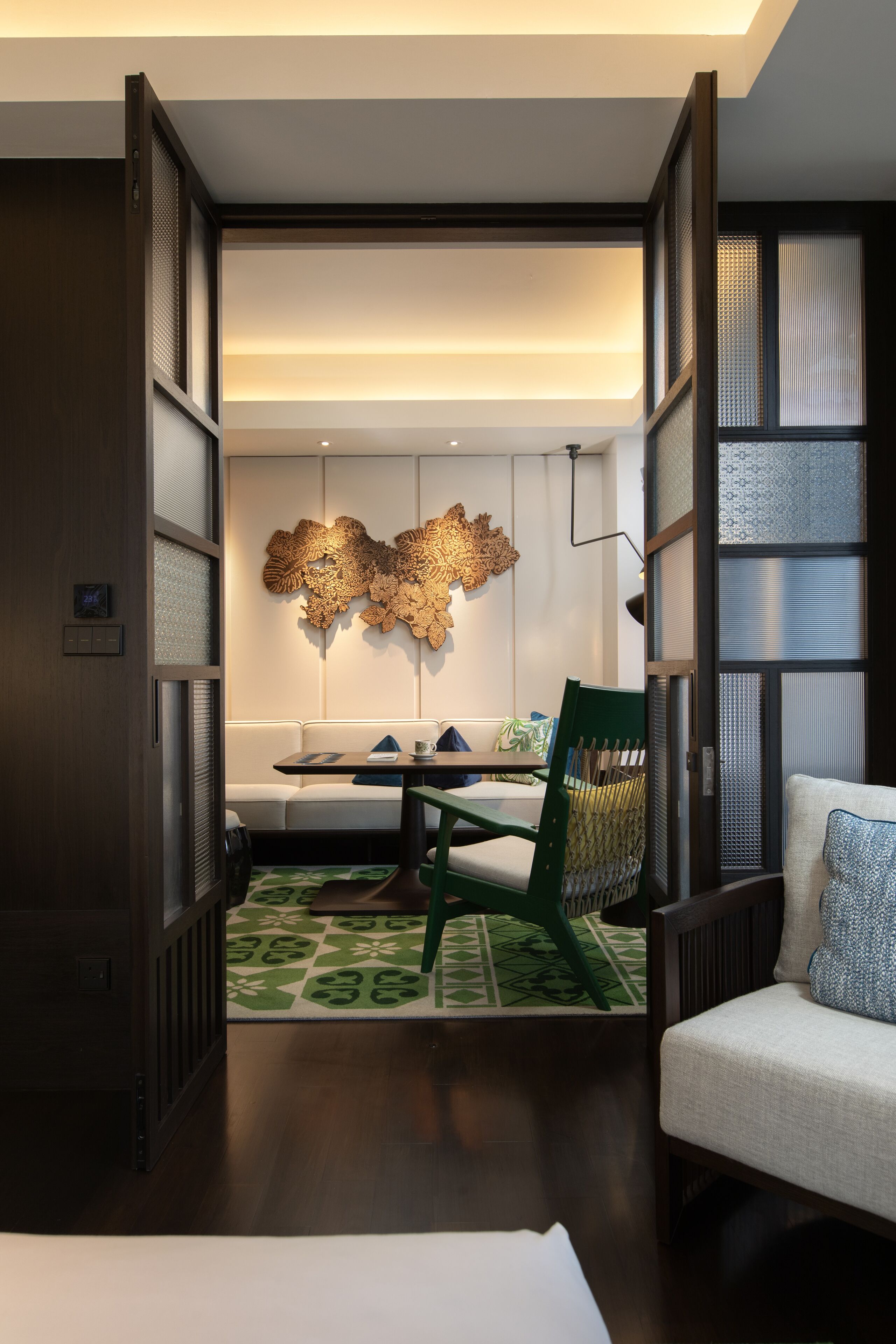 Un intérieur moderne comprenant un coin repas, un canapé et un élément décoratif mural.