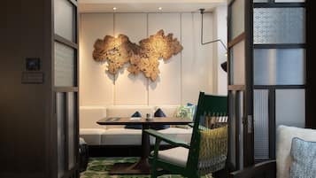 Un interior moderno con comedor, sofá y un elemento decorativo en la pared.