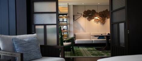 A modern living room with a sofa, a coffee table, and a green patterned rug.