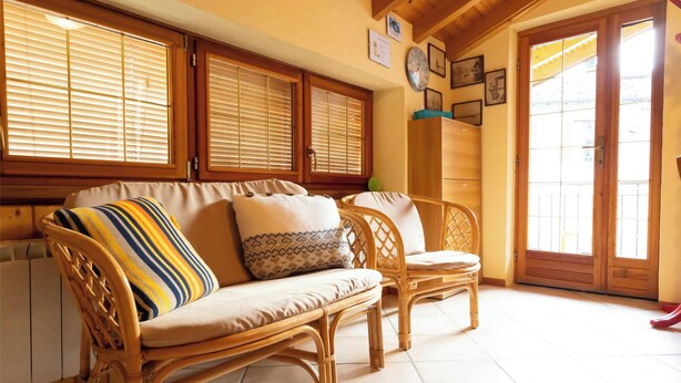 A room with a sofa set, a wooden chair, a wall clock, and a door with glass panels. - [Apartment in the Romantic Courtyard] Lake Lugano (Brusimpiano)