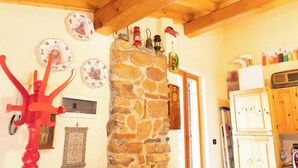A rustic kitchen with stone walls, wooden beams, and various kitchen appliances. - [Apartment in the Romantic Courtyard] Lake Lugano (Brusimpiano)