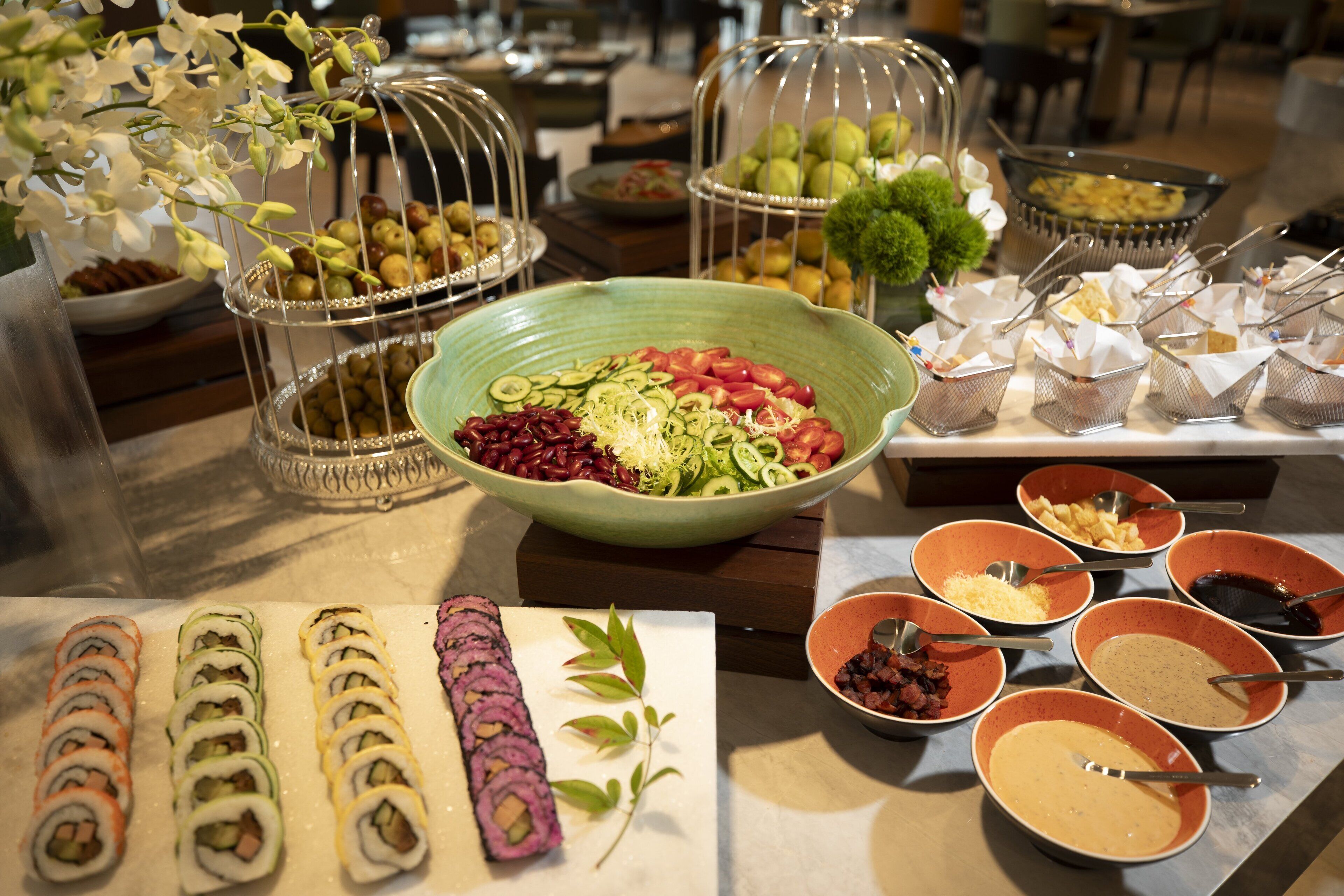 A buffet with various food items, including sushi, salads, and desserts.