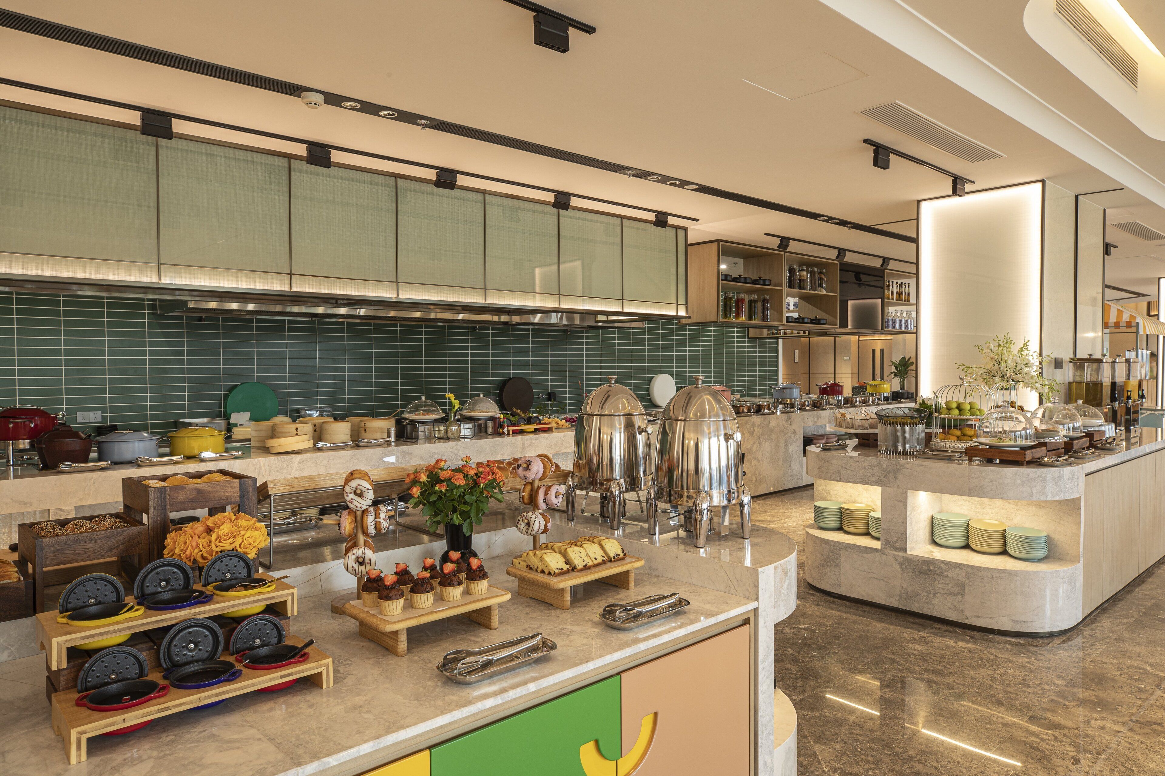 A modern kitchen with a buffet setup, including various food items and kitchen appliances.
