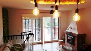 Un salon avec un canapé, une cheminée et un escalier.