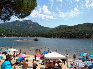 Guests can enjoy the beach with umbrellas and stunning mountain views.