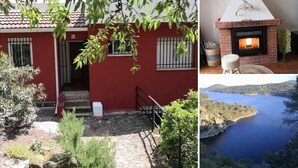 Un bâtiment rouge avec une cheminée en briques, un petit espace extérieur avec des marches et une vue sur une étendue d’eau.