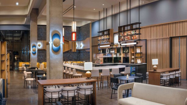 A modern bar area with a bar counter, seating, and a variety of bottles and glasses. - Hyatt Place Nashville Green Hills (Nashville)