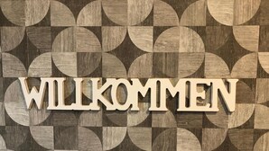 A geometric pattern with the word "WILKOMMEN" prominently displayed.