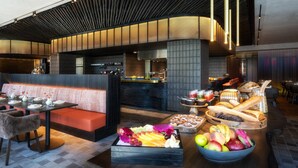 A modern restaurant with a long counter, seating area, and a variety of food and drink displays. - Intercontinental Auckland (Auckland)