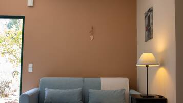 Una habitación con sofá, lámpara y un adorno en la pared.
