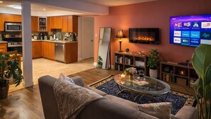 A modern living room with a sofa, coffee table, and a flat-screen TV mounted on the wall.