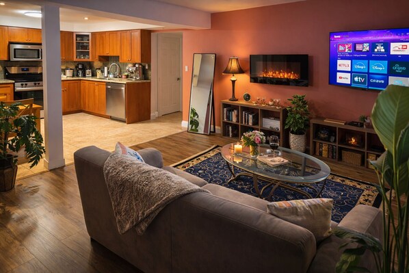 Una sala de estar moderna con un sofá, una mesa de centro y un televisor de pantalla plana montado en la pared.