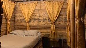 A room with a bed, a glass-top table, and curtains tied back. - San Vicente (San Vicente)